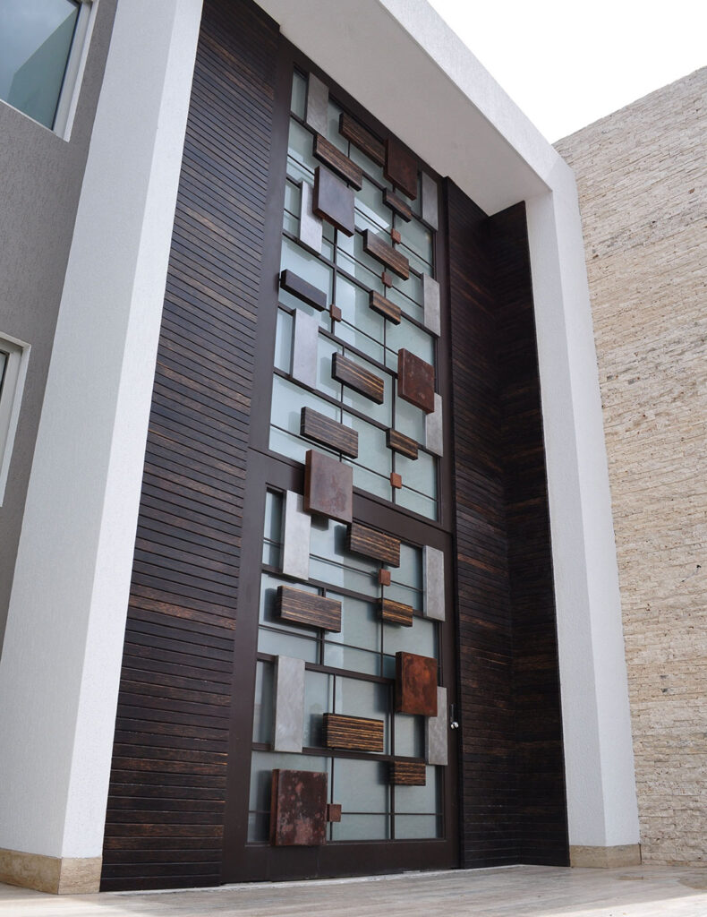 Oversized Wood Door Design, consists of small blocks of copper, aluminum, stainless steel, and bronze squares and rectangles that effortlessly blend in to create a modern design